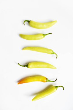 Yeşil sarı biber dilimleri / kesim / yarım beyaz arka planda izole, deri döşeme, üst manzara, beyaz masada Tayland biberi