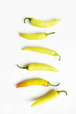 Yeşil sarı biber dilimleri / kesim / yarım beyaz arka planda izole, deri döşeme, üst manzara, beyaz masada Tayland biberi