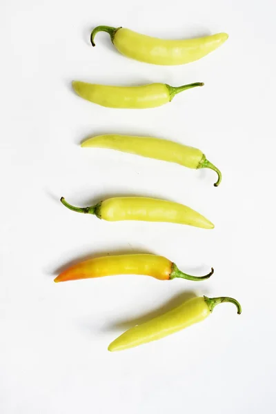 Green yellow chili peppers slices/cut/half isolated in white background, flay lay, top view, Thai chili in white table