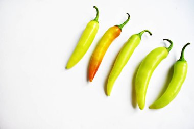 Yeşil sarı biber dilimleri / kesim / yarım beyaz arka planda izole, deri döşeme, üst manzara, beyaz masada Tayland biberi