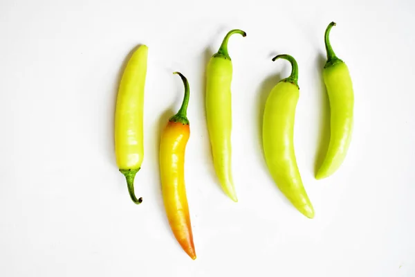 Green yellow chili peppers slices/cut/half isolated in white background, flay lay, top view, Thai chili in white table