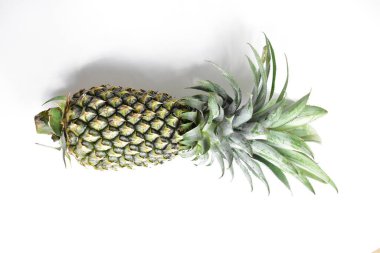 Yeşil ananas ve portakal ananasları, parlak sarı arka planda izole edilmiş taze tropikal meyve arka planında, yaz / bayram, yiyecek ve içecek, sulu, serin, vegan, sağlıklı gıda, fitness