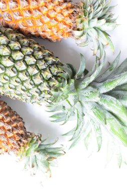 Yeşil ananas ve portakal ananasları, parlak sarı arka planda izole edilmiş taze tropikal meyve arka planında, yaz / bayram, yiyecek ve içecek, sulu, serin, vegan, sağlıklı gıda, fitness