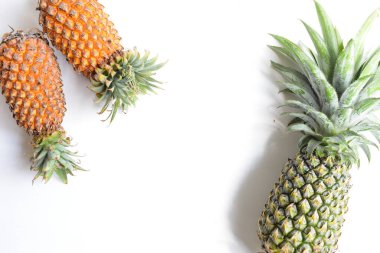 Yeşil ananas ve portakal ananasları, parlak sarı arka planda izole edilmiş taze tropikal meyve arka planında, yaz / bayram, yiyecek ve içecek, sulu, serin, vegan, sağlıklı gıda, fitness