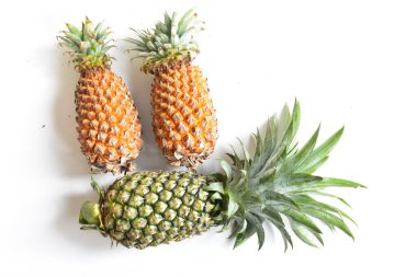 Yeşil ananas ve portakal ananasları, parlak sarı arka planda izole edilmiş taze tropikal meyve arka planında, yaz / bayram, yiyecek ve içecek, sulu, serin, vegan, sağlıklı gıda, fitness