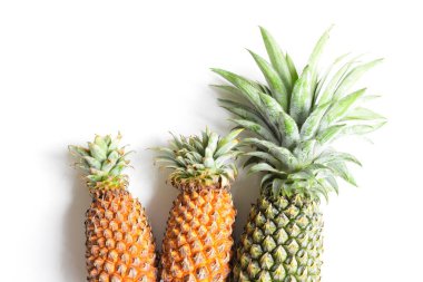 Yeşil ananas ve portakal ananasları, parlak sarı arka planda izole edilmiş taze tropikal meyve arka planında, yaz / bayram, yiyecek ve içecek, sulu, serin, vegan, sağlıklı gıda, fitness