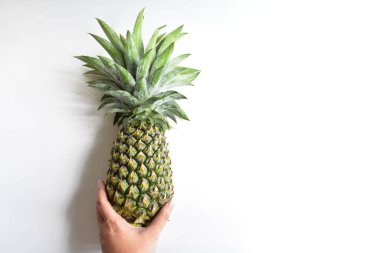 Yeşil ananas ve portakal ananasları, parlak sarı arka planda izole edilmiş taze tropikal meyve arka planında, yaz / bayram, yiyecek ve içecek, sulu, serin, vegan, sağlıklı gıda, fitness