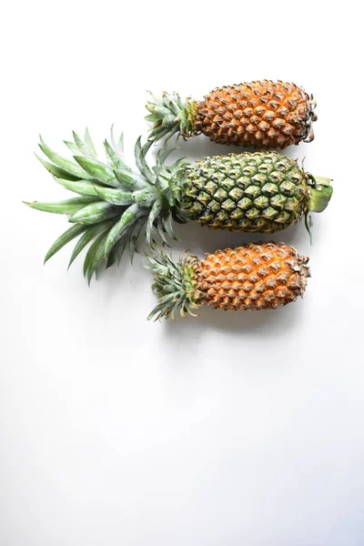 Green pineapple and orange pineapples isolated in bright yellow background, fresh tropical fruit background, summer/ holiday, food and beverage, juicy, cool, vegan, healthy food, fitness