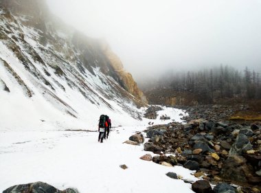 Çok sayıda insan, turistler karla kaplı bir yolda yürüyor..