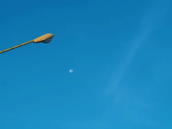 Torre Luz Rua Fundo Céu Azul Uma Pequena Lua Meio — Fotografia de Stock