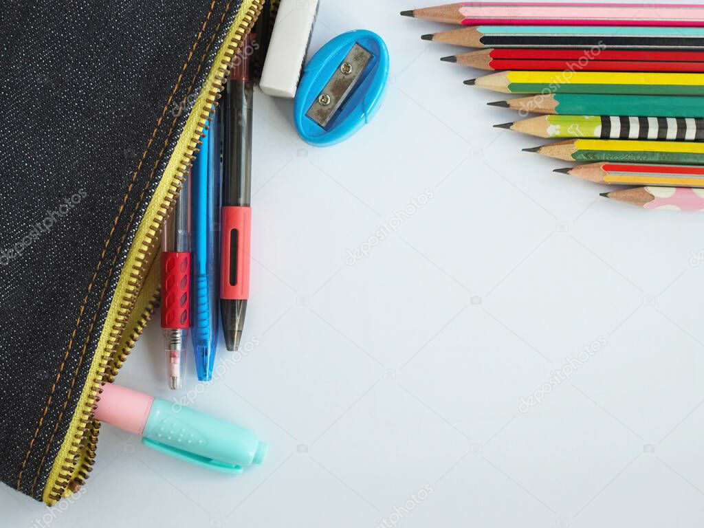 The top view of stationery in school bags and pencils arranged on a white background.