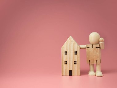 Tahta bebek evin yanında duruyor. evde kalmak için gerekli önlemlerin kullanılması teşvik edici.