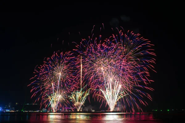 Kutlama gecesinde inanılmaz güzel renkli havai fişek gösterisi, deniz sahilinde su üzerinde çok renkli yansımalarla gösteriliyor. 