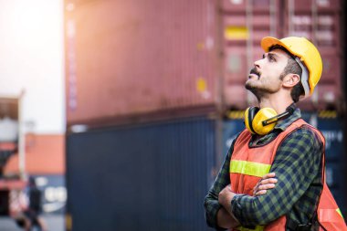 Sarı güvenlik kaskı takan Kafkasyalı mühendis ithalat ve ihracat, nakliye lojistik nakliye konteynır kutusunu kontrol ediyor.. 