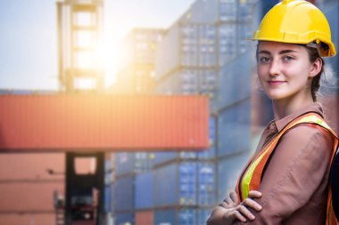 Sarı kasklı genç, kendine güvenen beyaz kadın mühendis ve kargo nakliye gemisinden ithalat ve ihracat için konteynır kutusunu kontrol et. 