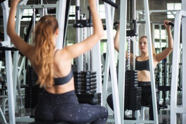 Genç, çekici, spor salonundaki halterli kadın egzersizinin sinematik tonu. Vücut kaslarını sağlıklı yaşam konseptine uydurmak için bireysel spor.
