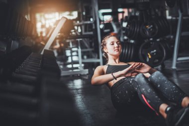 Genç, çekici, spor salonundaki halterli kadın egzersizinin sinematik tonu. Vücut kaslarını sağlıklı yaşam konseptine uydurmak için bireysel spor.