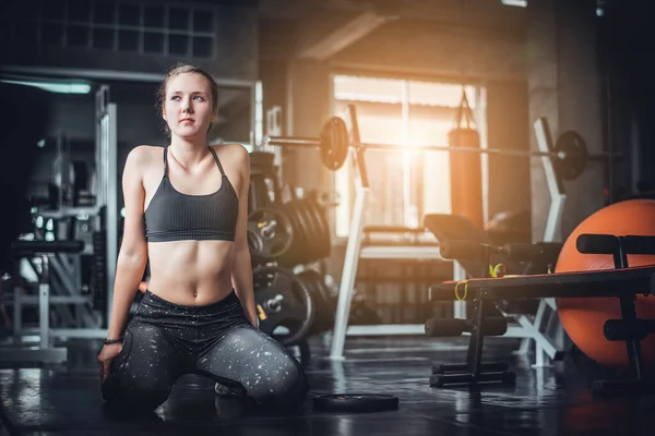 운동을 매력적 여성의 음색이 체육관에서 기계와 덤벨을 가지고 운동을 개념을 — 스톡 사진