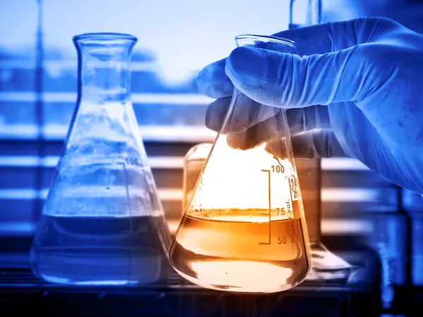Hand Van Een Wetenschapper Met Kolf Met Laboratoriumglaswerk Chemische Laboratoriumachtergrond — Stockfoto