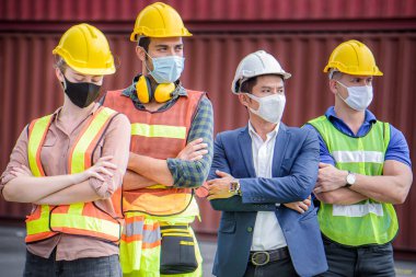 Mühendis ekibi, petrol ve gaz rafinerisi arka planında elleri kolları bağlı bir şekilde bekliyor. İthalat ve ihracat için kargo gemisi. Takım Çalışması Konsepti