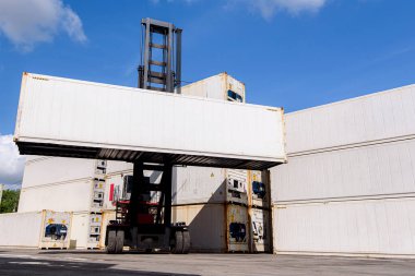 Uluslararası deniz taşımacılığı için konteyner limanında forklift yükleme kutusu. İthalat ve ihracat için kargo gemisi, nakliye