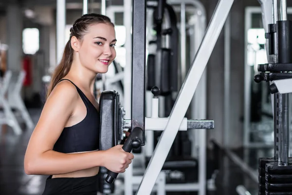 운동하는 매력적 여성의 음색이 체육관에서 기계와 — 스톡 사진
