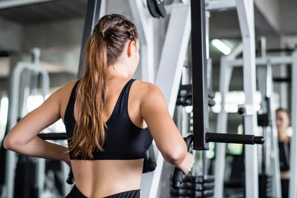 Genç Çekici Kadın Spor Salonundaki Makineyle Egzersiz Yapıyor — Stok fotoğraf