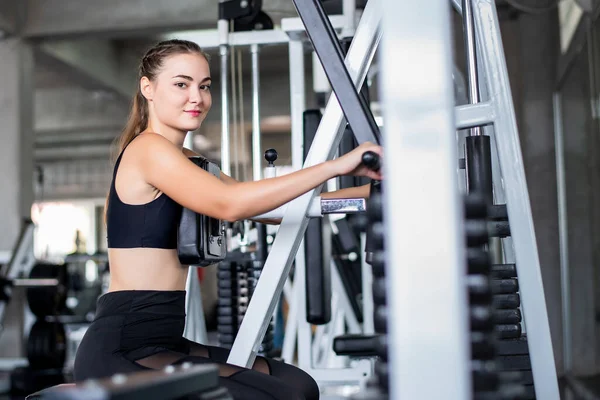 Genç Çekici Kadın Spor Salonundaki Makineyle Egzersiz Yapıyor — Stok fotoğraf