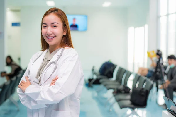 Portrait of attractive female doctor with blur hospital lobby background