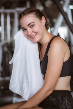 Genç çekici, terini silmek için havlu kullanıyor. Spor salonunda sıkı çalıştıktan sonra rahatlama..  