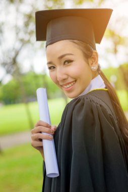 Mezuniyet şapkası ve cübbesi takan mezun kadın öğrenciler.