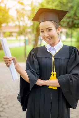 Mezuniyet şapkası ve cübbesi takan mezun kadın öğrenciler.