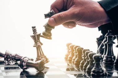 İş adamı satranç taşını hareket ettiriyor ve oyunu kazanmak için stratejik düşünüyor. Fikirler, rekabet ve strateji için satranç tahtası konsepti, iş başarısı konsepti 
