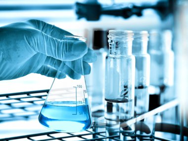 Laboratuvar geçmişi, bilim laboratuarı araştırma ve geliştirme konsepti ve laboratuvar malzemeleriyle dolu bir matarayı tutan bilim adamının eli.