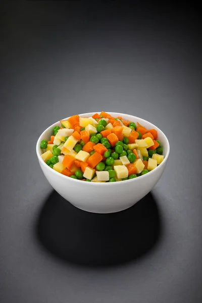 Siyaha izole edilmiş taze karışık sebzeler. Rus salatası.