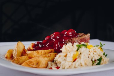 Kızarmış biftek ve kiraz soslu patates.