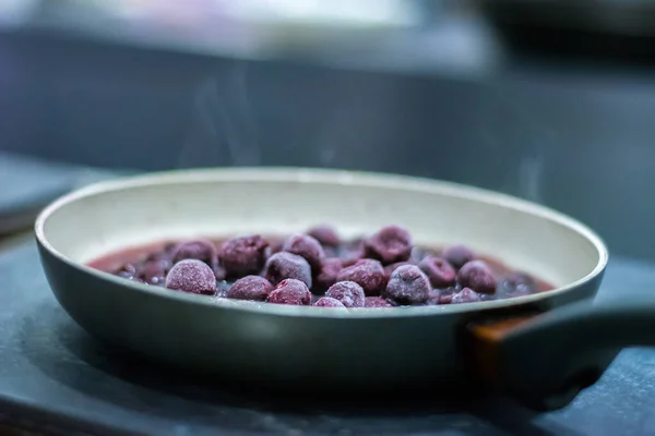 Donmuş kirazlar tavada dondurulmuş kirazlar. Buzları eritiyorum. Çözünüyor.