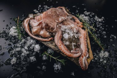 Taş bir masadaki bütün çiğ ahtapot.