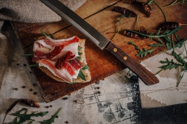 Tahta üzerinde dilimlenmiş domuz pastırması.