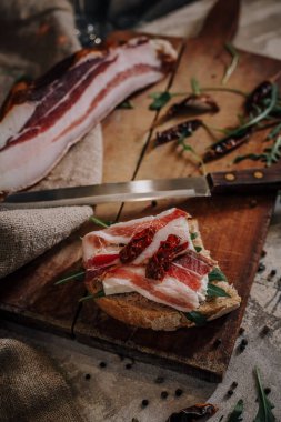 Tahta üzerinde dilimlenmiş domuz pastırması.