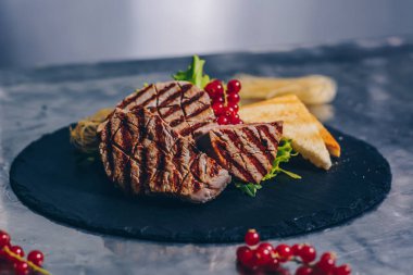 Siyah taş tahtada ızgara biftek.