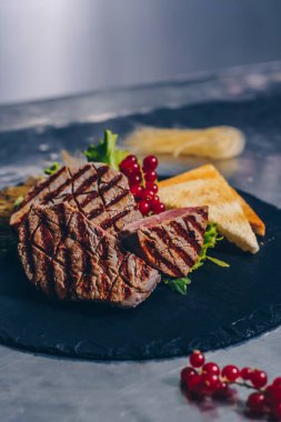 Siyah taş tahtada ızgara biftek.