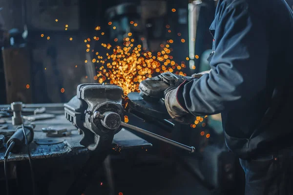 Industrial metal worker use the grinder in factory