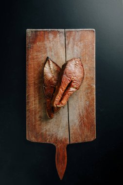 Klasik kesim tahtasının üzerinde tütsülenmiş somon dilimi