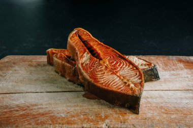 Klasik kesim tahtasının üzerinde tütsülenmiş somon dilimi