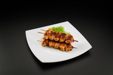 Domuz pastırmasına sarılı ızgara tavuk şişleri..