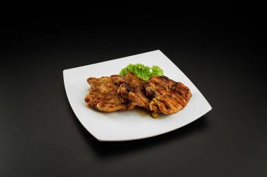 Beyaz tabakta ızgara kemiksiz tavuk bacağı.. 