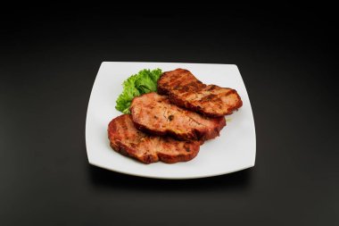 Beyaz tabakta ızgara domuz budu.