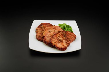 Beyaz tabakta ızgara domuz budu.