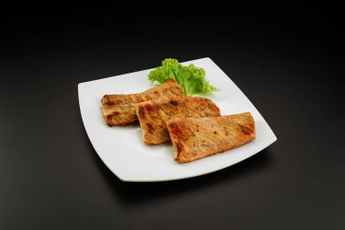 Beyaz tabakta ızgara domuz eti.